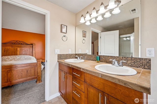 10089 Jensen Dr SE, Yelm, WA 98597 - full bath with double vanity, tasteful backsplash, a shower with shower door, and tile patterned flooring