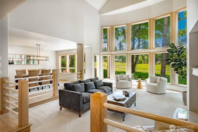 5520 Canvasback Rd, Blaine, WA 98230 - living room with light colored carpet, a high ceiling, and a chandelier
