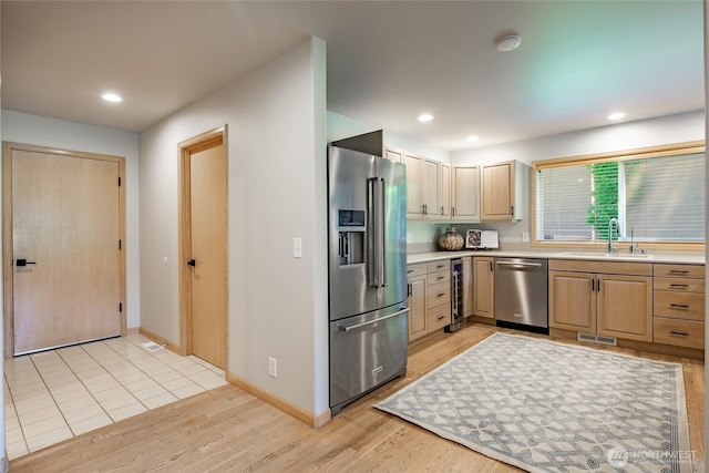 5520 Canvasback Rd, Blaine, WA 98230 - kitchen featuring appliances with stainless steel finishes, a sink, beverage cooler, light brown cabinetry, and light countertops