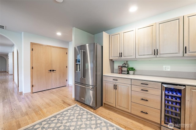 5520 Canvasback Rd, Blaine, WA 98230 - kitchen featuring high quality fridge, beverage cooler, arched walkways, light wood-type flooring, and light countertops