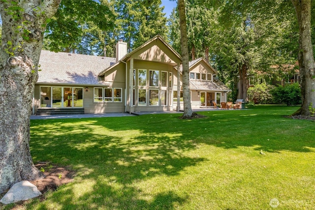 5520 Canvasback Rd, Blaine, WA 98230 - back of property with a chimney, a lawn, and a patio area