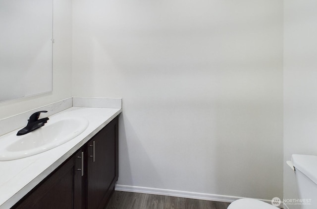 704 N 3rd St, Westport, WA 98595 - bathroom with toilet, vanity, baseboards, and wood finished floors