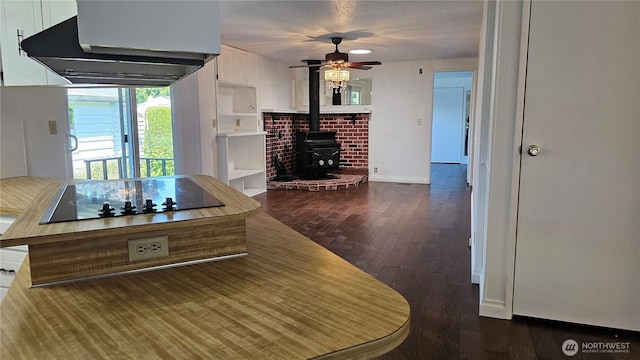 1402 22nd St NE Unit 252, Auburn, WA 98002 - kitchen featuring range hood, a wood stove, black electric stovetop, wood finished floors, and a ceiling fan