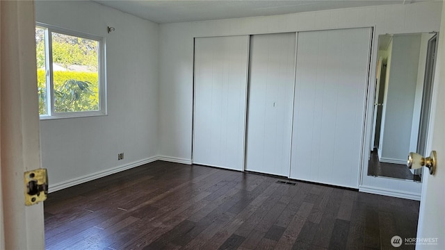 1402 22nd St NE Unit 252, Auburn, WA 98002 - unfurnished bedroom featuring dark wood-type flooring, a closet, and baseboards