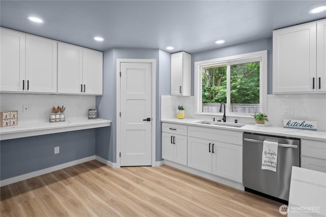 18604 9th Avenue Ct E, Spanaway, WA 98387 - kitchen with stainless steel dishwasher, built in desk, tasteful backsplash, light wood-type flooring, and white cabinetry