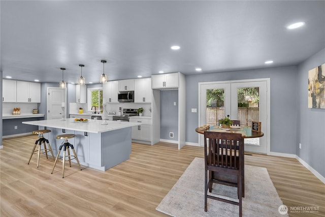 18604 9th Avenue Ct E, Spanaway, WA 98387 - kitchen featuring stainless steel appliances, white cabinets, light wood finished floors, and recessed lighting