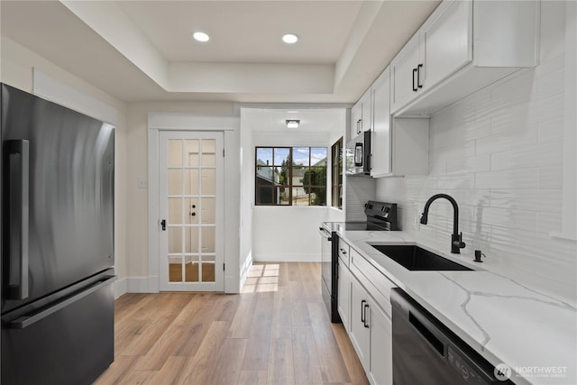 422 S Wright Ave, Tacoma, WA 98418 - kitchen featuring appliances with stainless steel finishes, light wood-style flooring, backsplash, light stone countertops, and white cabinets