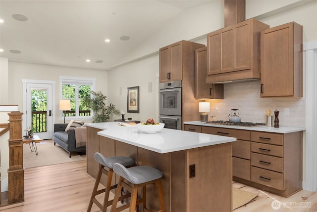 17765 25th Ave NE, Shoreline, WA 98155 - kitchen with appliances with stainless steel finishes, tasteful backsplash, vaulted ceiling, a center island, and a breakfast bar