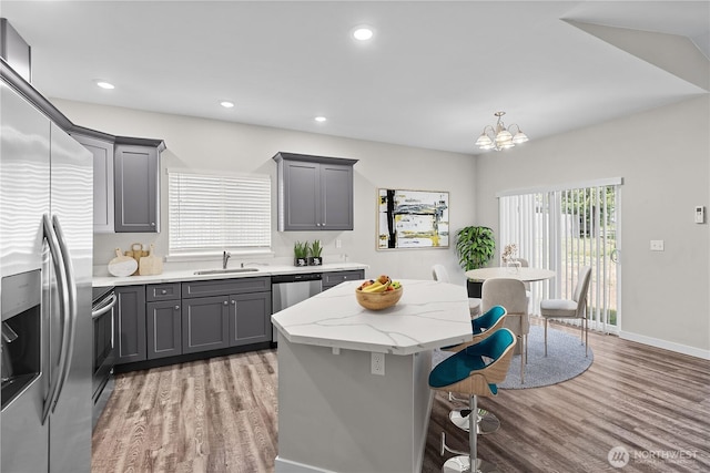 17621 Vine Ln SE, Yelm, WA 98597 - kitchen with appliances with stainless steel finishes, gray cabinetry, light wood-style floors, a breakfast bar area, and recessed lighting