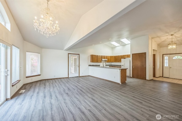 5 Bayview Ln, Hoquiam, WA 98550 - unfurnished living room with a chandelier, a sink, high vaulted ceiling, wood finished floors, and baseboards