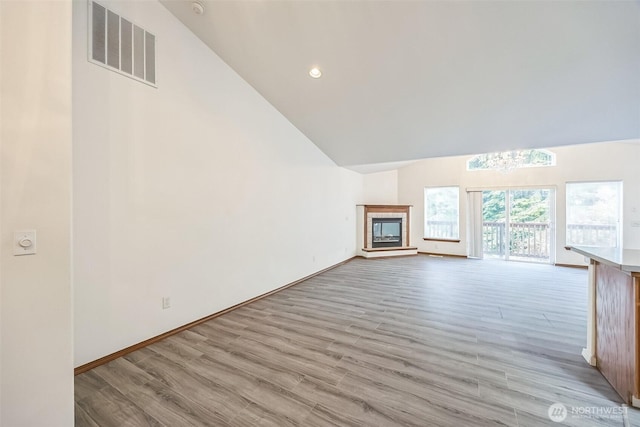 5 Bayview Ln, Hoquiam, WA 98550 - unfurnished living room featuring high vaulted ceiling, light wood finished floors, baseboards, a fireplace, and recessed lighting