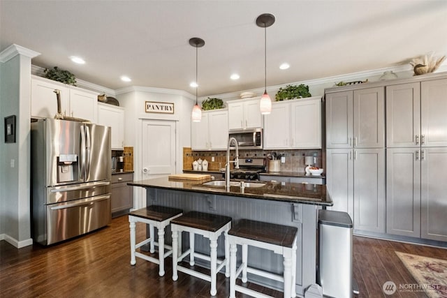 19409 90th Avenue Ct E, Graham, WA 98338 - kitchen featuring appliances with stainless steel finishes, a kitchen breakfast bar, tasteful backsplash, pendant lighting, and dark stone counters