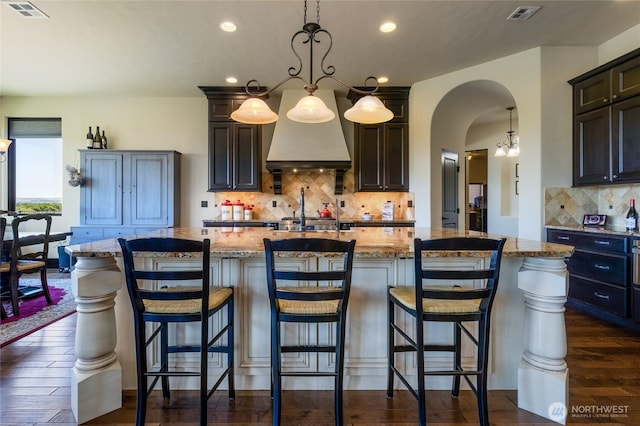 2316 Ridgeview Rd, Walla Walla, WA 99362 - kitchen with backsplash, light stone counters, recessed lighting, a center island with sink, and dark wood-style flooring