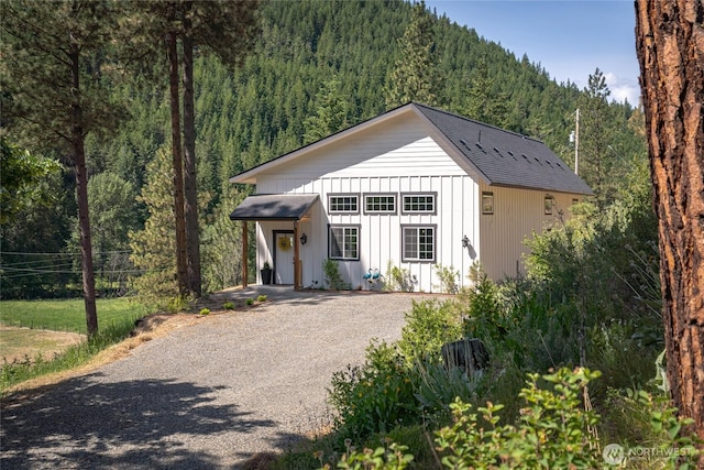 10642 Merry Canyon Rd, Leavenworth, WA 98820 - modern inspired farmhouse featuring a forest view, board and batten siding, gravel driveway, and a shingled roof
