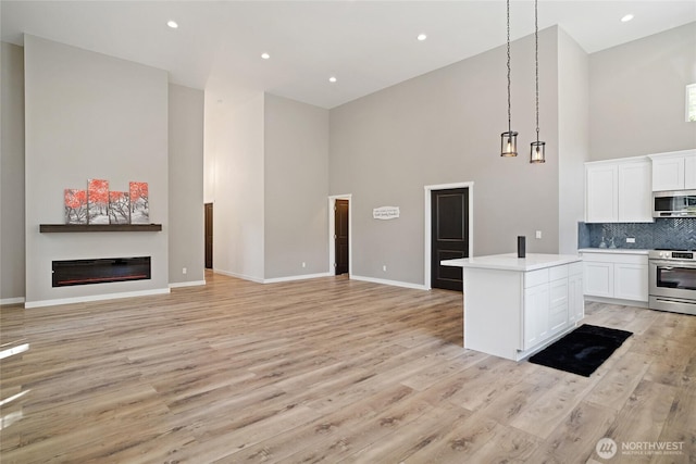 10642 Merry Canyon Rd, Leavenworth, WA 98820 - kitchen featuring stainless steel appliances, high vaulted ceiling, light wood-type flooring, decorative backsplash, and white cabinetry