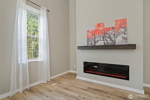 10642 Merry Canyon Rd, Leavenworth, WA 98820 - unfurnished living room with a glass covered fireplace, wood finished floors, and baseboards