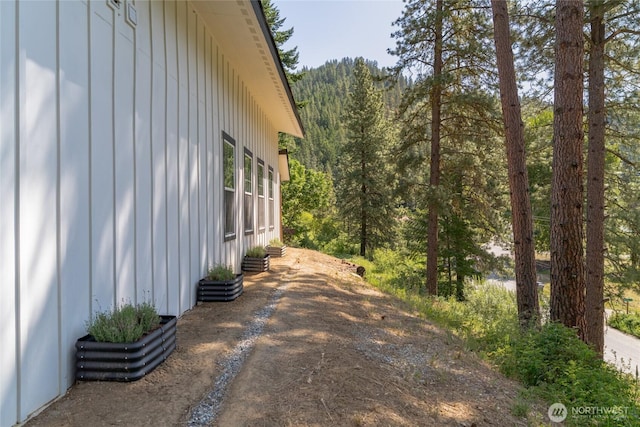 10642 Merry Canyon Rd, Leavenworth, WA 98820 - view of side of home featuring board and batten siding, a view of trees, and driveway