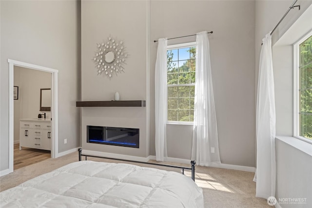 10642 Merry Canyon Rd, Leavenworth, WA 98820 - bedroom with carpet floors, a towering ceiling, a glass covered fireplace, and multiple windows