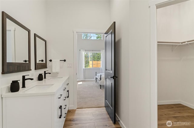 10642 Merry Canyon Rd, Leavenworth, WA 98820 - full bath featuring wood finished floors, double vanity, a towering ceiling, baseboards, and a spacious closet