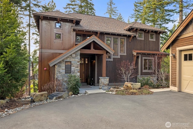 420 Black Nugget Ln, Cle Elum, WA 98922 - view of front facade featuring a shingled roof, stone siding, driveway, and a garage