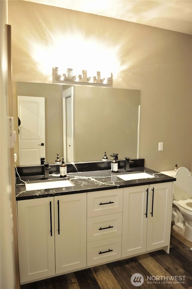 613 Aster Ct SE, Ocean Shores, WA 98569 - bathroom with double vanity, toilet, and wood finished floors