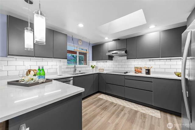 2463 74th Ave SE, Mercer Island, WA 98040 - kitchen featuring gray cabinets, under cabinet range hood, freestanding refrigerator, pendant lighting, and a skylight
