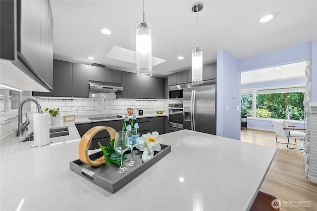 2463 74th Ave SE, Mercer Island, WA 98040 - kitchen featuring stainless steel appliances, under cabinet range hood, pendant lighting, backsplash, and gray cabinetry
