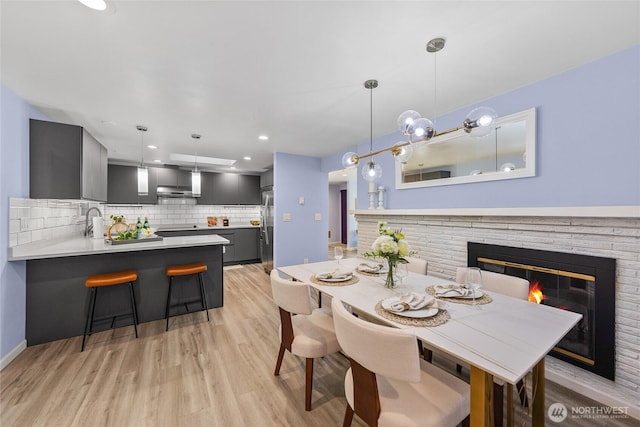 2463 74th Ave SE, Mercer Island, WA 98040 - dining space with light wood-style floors, a glass covered fireplace, and recessed lighting