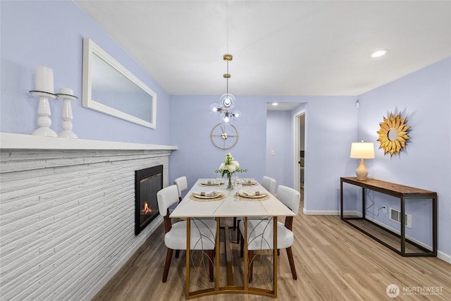 2463 74th Ave SE, Mercer Island, WA 98040 - dining space featuring wood finished floors, a glass covered fireplace, and recessed lighting