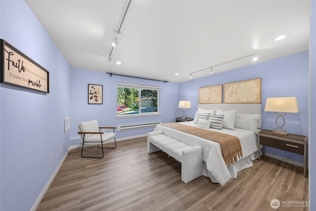 2463 74th Ave SE, Mercer Island, WA 98040 - bedroom featuring rail lighting, wood finished floors, and a baseboard heating unit