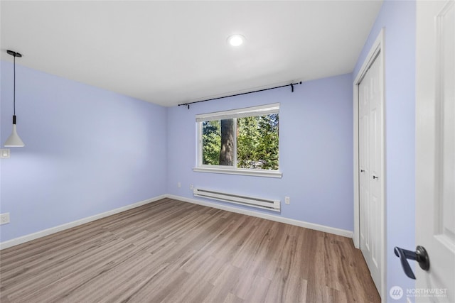 2463 74th Ave SE, Mercer Island, WA 98040 - unfurnished bedroom featuring baseboard heating, wood finished floors, a closet, and recessed lighting