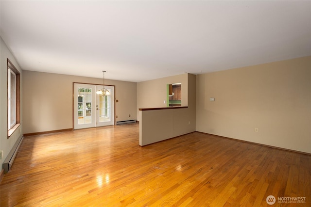 7823 Parker Rd, Sedro Woolley, WA 98284 - unfurnished living room featuring a chandelier, baseboard heating, and light wood-type flooring
