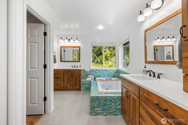 6817 Picnic Point Rd, Edmonds, WA 98026 - full bathroom with two vanities, a whirlpool tub, and wood finished floors
