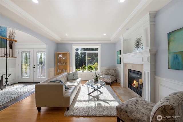 6817 Picnic Point Rd, Edmonds, WA 98026 - living area featuring a fireplace with flush hearth, wainscoting, arched walkways, wood finished floors, and a tray ceiling