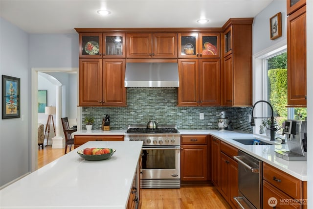 6817 Picnic Point Rd, Edmonds, WA 98026 - kitchen with wall chimney range hood, stainless steel appliances, a sink, light countertops, and recessed lighting