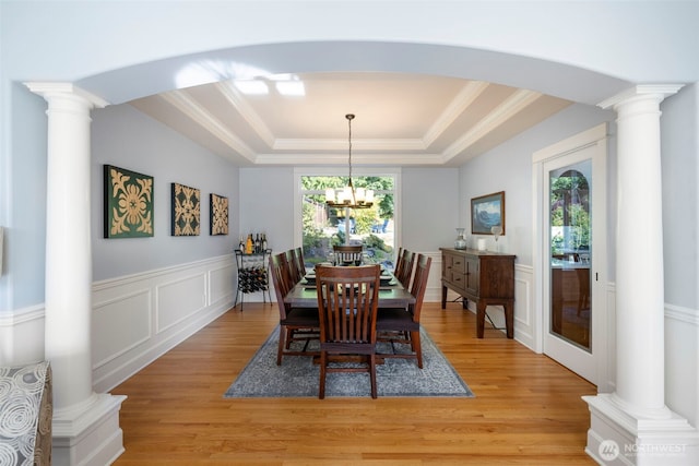 6817 Picnic Point Rd, Edmonds, WA 98026 - dining area featuring a tray ceiling, light wood-style flooring, arched walkways, a decorative wall, and ornate columns