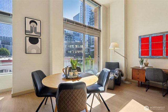 900 Lenora St Unit W106, Seattle, WA 98121 - dining room with wood finished floors, plenty of natural light, a city view, and a towering ceiling
