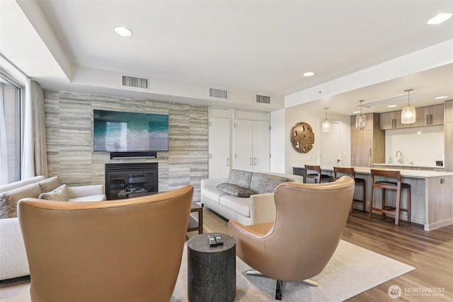 900 Lenora St Unit W106, Seattle, WA 98121 - living room with a tile fireplace, wet bar, wood finished floors, recessed lighting, and an accent wall