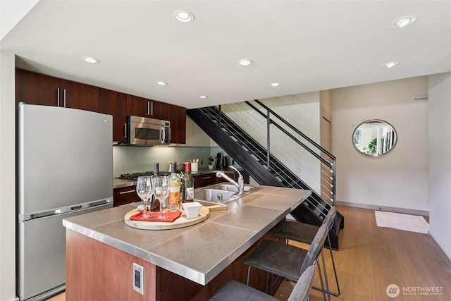900 Lenora St Unit W106, Seattle, WA 98121 - kitchen featuring stainless steel appliances, a kitchen bar, recessed lighting, light wood finished floors, and modern cabinets