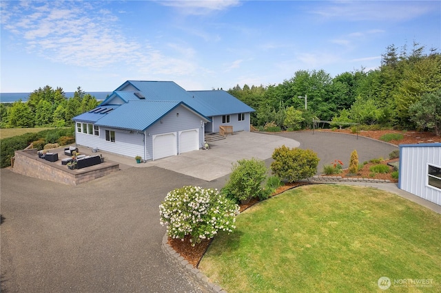 24 Jacalyn Ln, Grayland, WA 98547 - view of front of property with a garage, a front yard, metal roof, and driveway