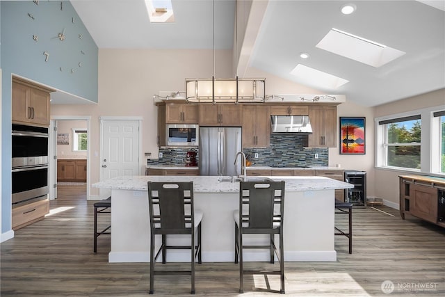 24 Jacalyn Ln, Grayland, WA 98547 - kitchen featuring appliances with stainless steel finishes, a skylight, wine cooler, a sink, and backsplash