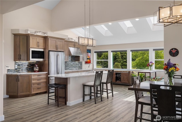24 Jacalyn Ln, Grayland, WA 98547 - kitchen with appliances with stainless steel finishes, a chandelier, tasteful backsplash, a kitchen breakfast bar, and high vaulted ceiling