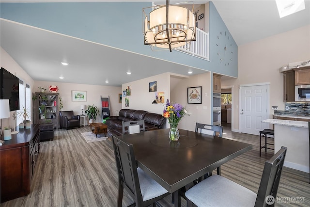 24 Jacalyn Ln, Grayland, WA 98547 - dining space featuring wood finished floors, a high ceiling, a chandelier, plenty of natural light, and a skylight