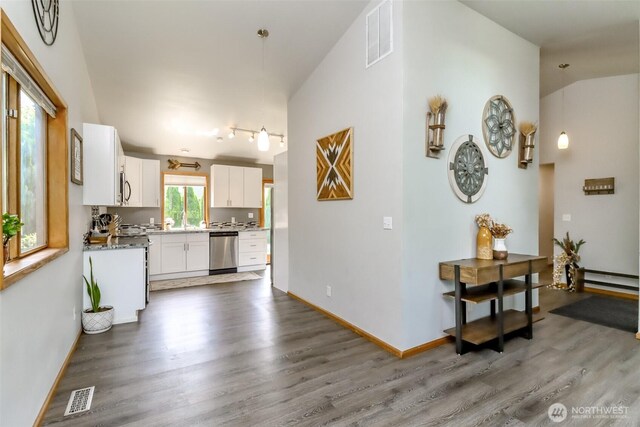 6002 35th Way SE, Auburn, WA 98092 - kitchen with appliances with stainless steel finishes, wood finished floors, white cabinetry, a baseboard heating unit, and lofted ceiling