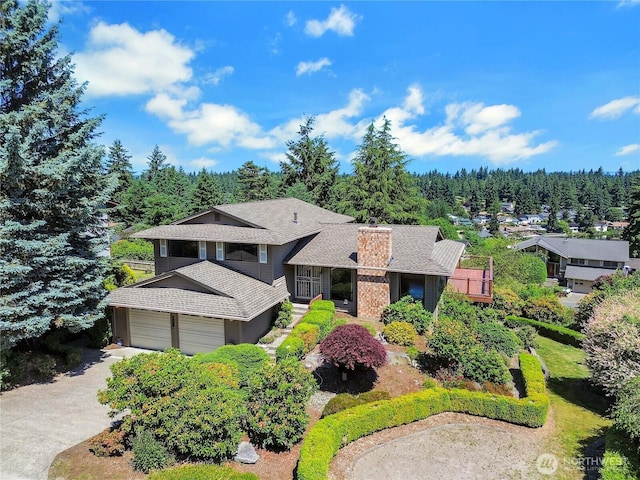 4026 SW 328th St, Federal Way, WA 98023 - view of front of home with roof with shingles, a chimney, a garage, driveway, and a wooded view