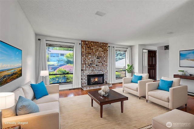 4026 SW 328th St, Federal Way, WA 98023 - living area featuring wood finished floors, a brick fireplace, and a textured ceiling