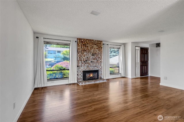 4026 SW 328th St, Federal Way, WA 98023 - unfurnished living room featuring a textured ceiling, wood finished floors, healthy amount of natural light, and a brick fireplace
