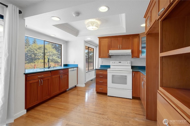 4026 SW 328th St, Federal Way, WA 98023 - kitchen with white appliances, under cabinet range hood, a raised ceiling, brown cabinetry, and light wood-style flooring