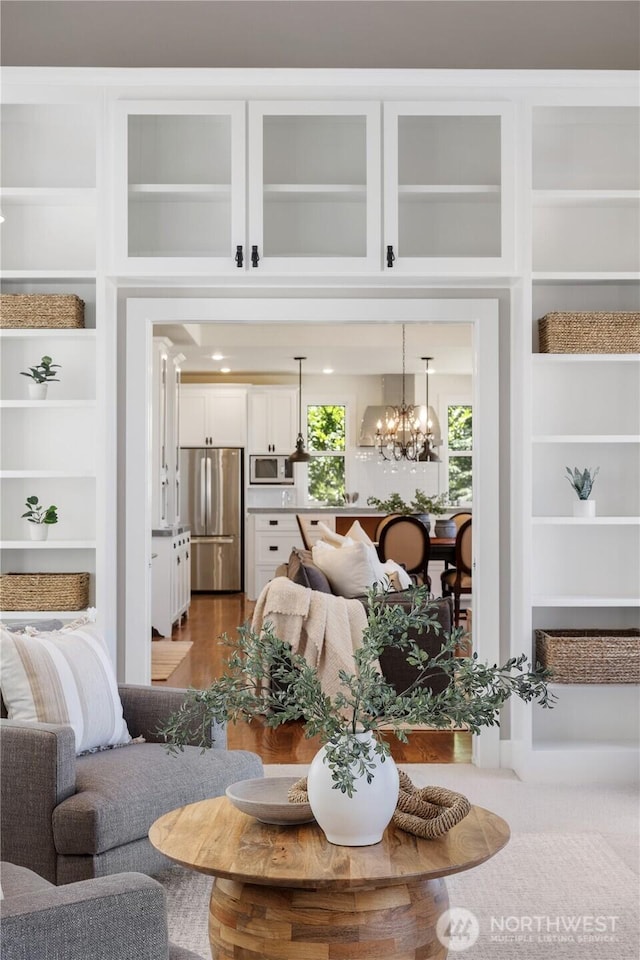 2575 Bretland Rd, Camano Island, WA 98282 - living room featuring built in shelves, dark wood-style floors, and a chandelier