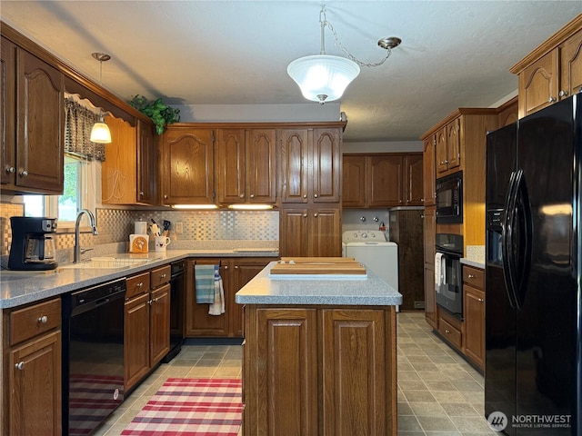 4208 W Okanogan Ave, Kennewick, WA 99336 - kitchen with black appliances, washer / clothes dryer, a sink, a kitchen island, and backsplash
